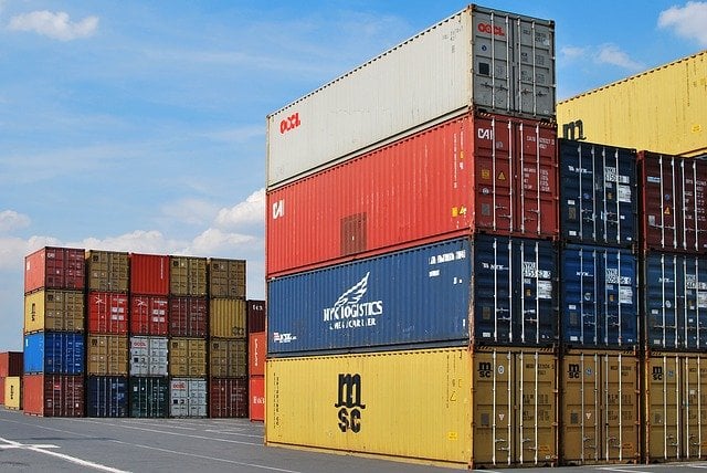 A dock filled with shipping containers of different sizes.