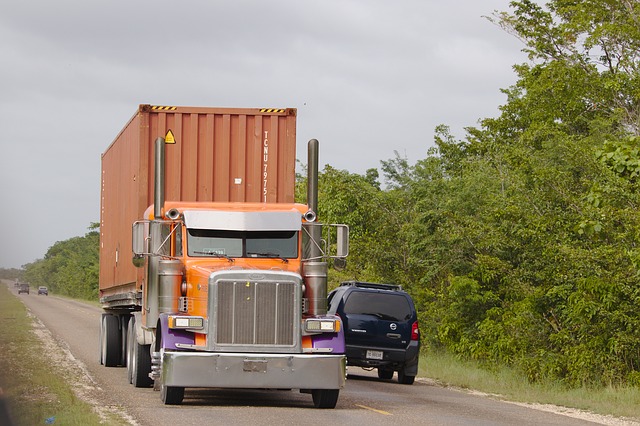 A truck on the road delivering a shipping container.