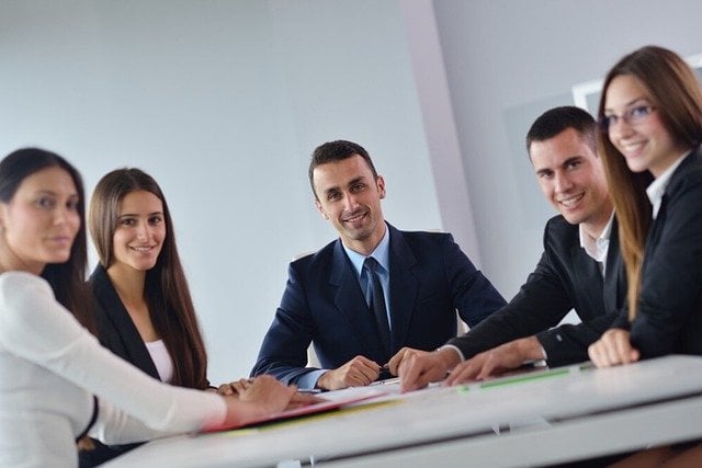 A team of people sitting at a desk.